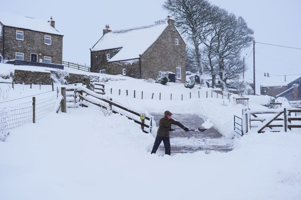 A man clears snow near Allenheads (Owen Humphreys/PA)