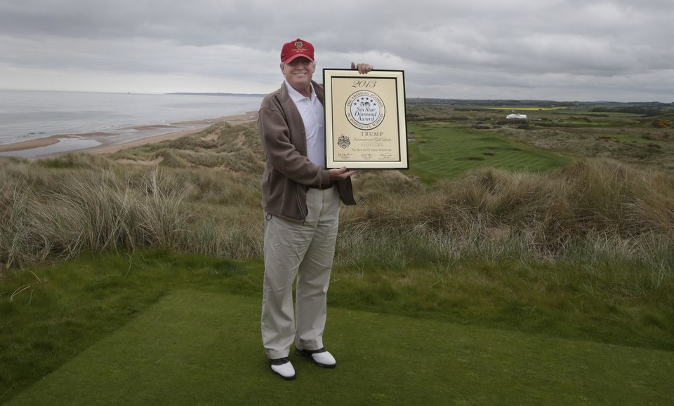 Donald Trump holds an award for The Best Golf Course Worldwide from The American Academy of Hospitality Sciences at the Trump International Golf Links in Aberdeenshire in June 2013 (Danny Lawson/PA)