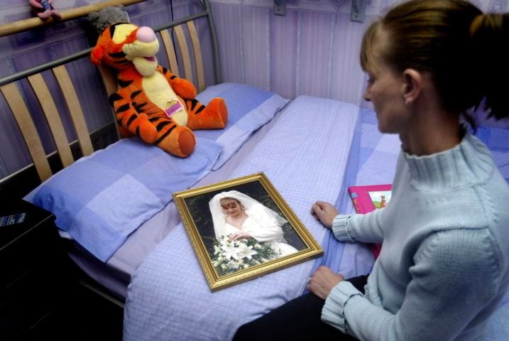 Mum Linda Brown with a photo of Nichola in the bedroom where she was murdered.