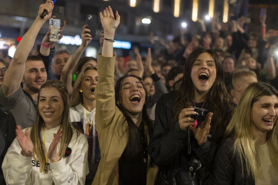 People celebrate as the university students arrive (Marko Drobnjakovic/AP)