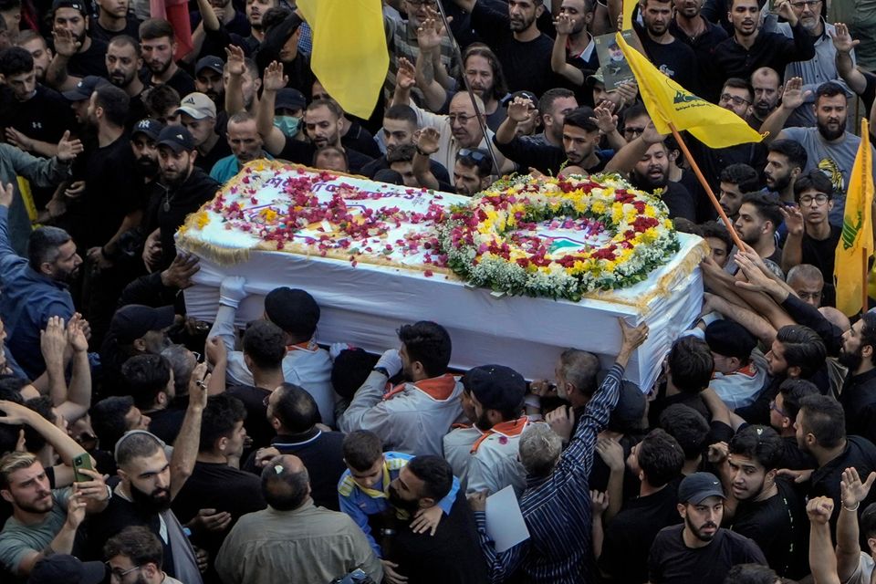 Mourners carry the coffins of victims who were killed after their handheld pagers exploded in Beirut (Bilal Hussein/AP)