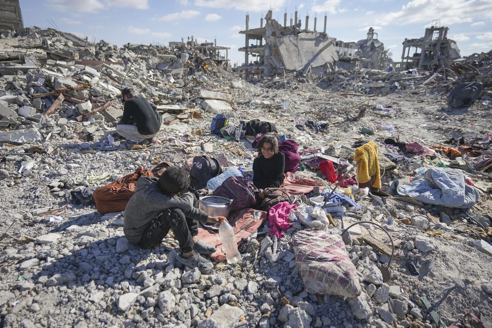 Nour and her brother Mohamed Ballas try to salvage what they can of their belongings from the rubble of their home in Rafah (Abdel Kareem Hana/AP)