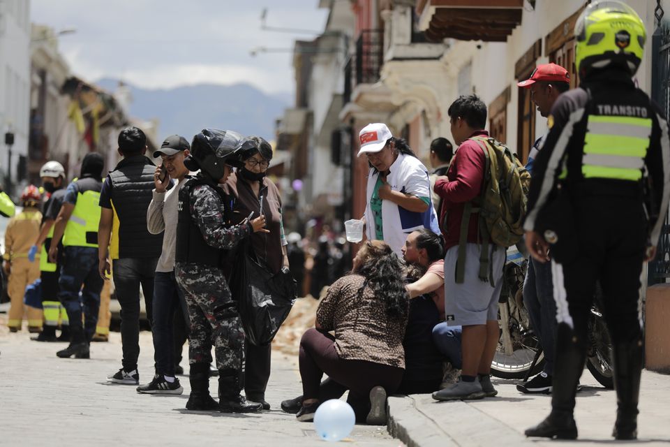 Police near where a car was crushed by debris after an earthquake shook Cuenca, Ecuador (Xavier Caivinagua/AP/PA)