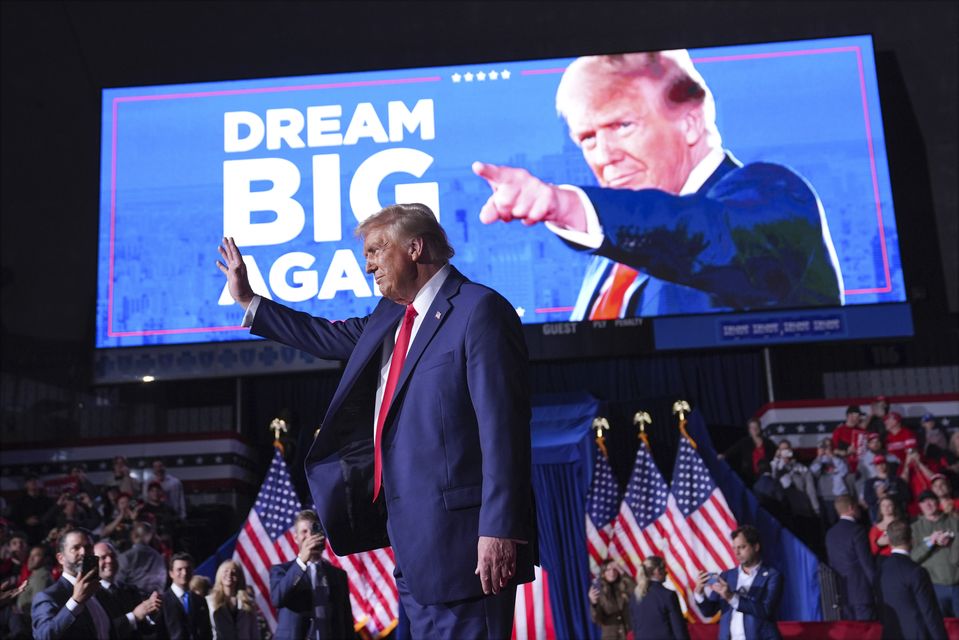 Donald Trump waves at a campaign rally at Van Andel Arena in Grand Rapids, Michigan on Monday night (Evan Vucci/AP)