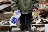 thumbnail: Boy carries bottles of water amid debris in Kesennuma, northern Japan Monday, March 14, 2011 following Friday's massive earthquake and the ensuing tsunami. (AP Photo/Kyodo News) JAPAN OUT, MANDATORY CREDIT, NO SALES IN CHINA, HONG  KONG, JAPAN, SOUTH KOREA AND FRANCE, CORRECTS DATE PHOTO TAKEN