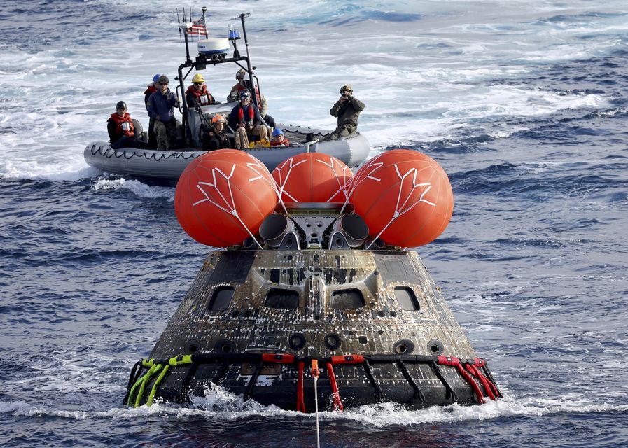 FILE – Nasa’s Orion capsule is drawn to the well deck of the USS Portland after it splashed down following a successful uncrewed Artemis I moon mission (Mario Tama via AP File)