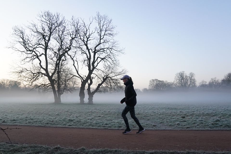 A jogger runs in the morning fog of Morden Hall Park, south London (Ben Whitley/PA)