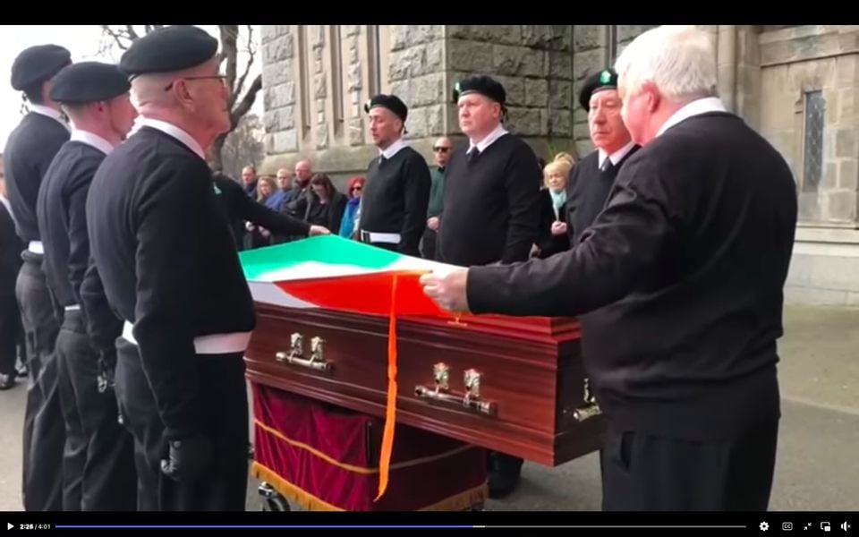 The flag-draped coffin arrives at the church