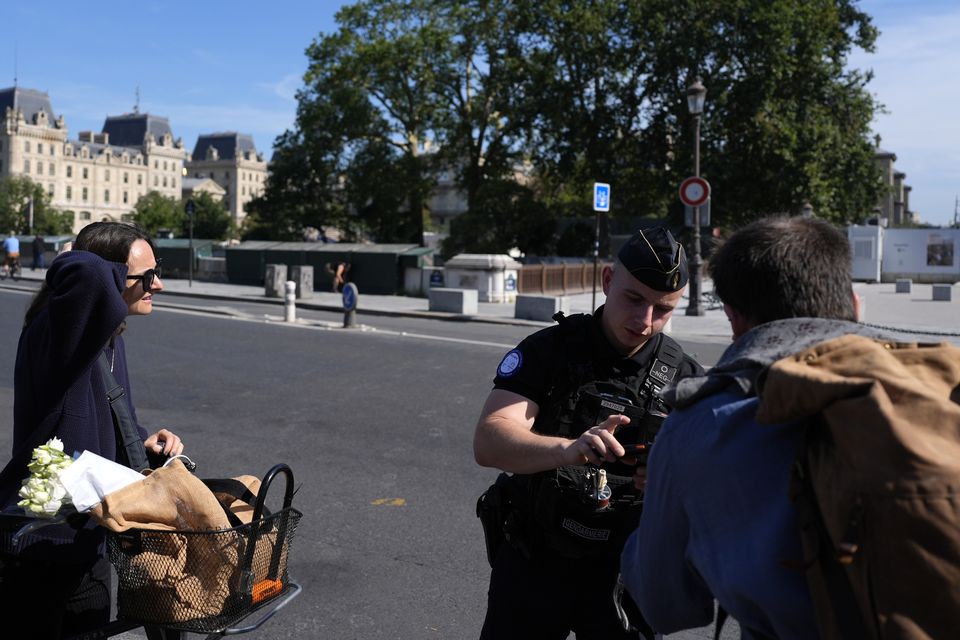 A police officer checks people at the security perimeter (David Goldman/AP)