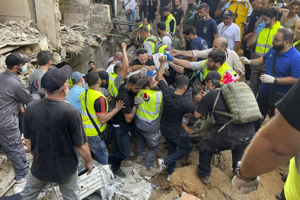 Rescuers carry a body at the scene of a missile strike in the southern suburbs of Beirut (Bilal Hussein/AP)