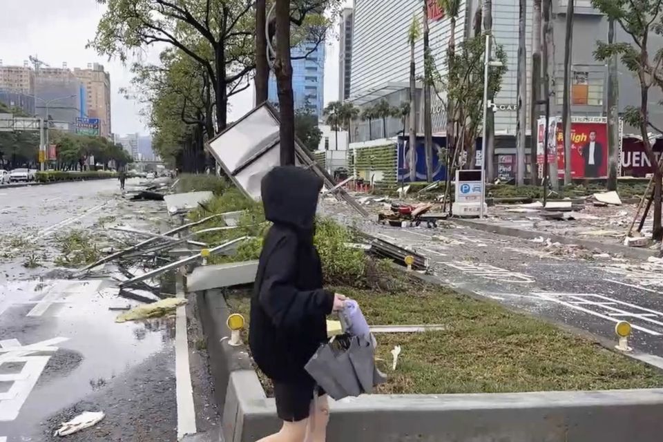 A person walks past debris from an explosion at the Shin Kong Mitsukoshi department store in Taichung city in Taiwan (TVBS via AP )