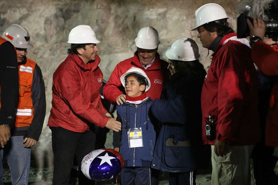 SAN JOSE MINE, CHILE - OCTOBER 12: (NO SALES, NO ARCHIVE) In this handout from the Chilean government, Chilean President Sebastian Pinera and Mining Minister Laurence Golborne stand with the family of Florencio Avalos while waiting for the trapped miner to exit the mine in the rescue capsule October 12, 2010 at the San Jose mine near Copiapo, Chile. The rescue operation has begun bringing up the 33 miners, 69 days after the August 5th collapse that trapped them half a mile underground. (Photo by Hugo Infante/Chilean Government via Getty Images)