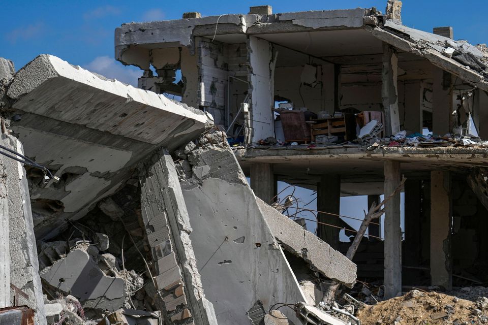 A Palestinian man and two girls stand amid rubble of homes destroyed by the Israeli army’s air and ground offensive against Hamas in in Bureij refugee camp, central Gaza Strip (AP Photo/Abdel Kareem Hana)