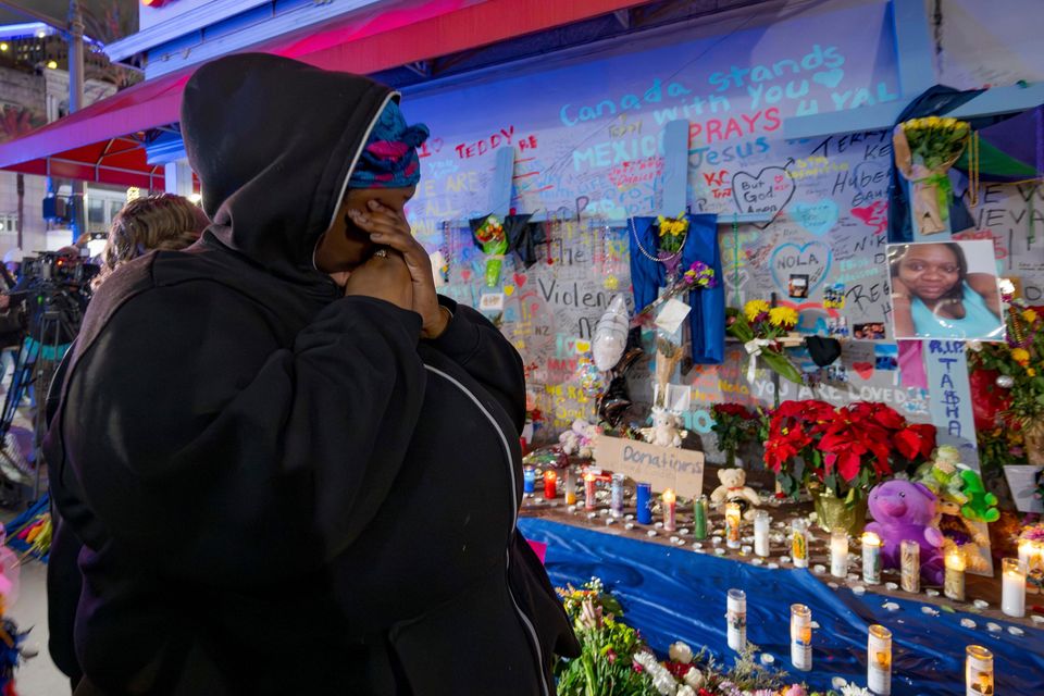 Courtney Polk, a cousin of Tasha Polk, who was killed in the New Year’s Day attack, wipes a tear as she reads messages left in tribute (Matthew Hinton/AP)