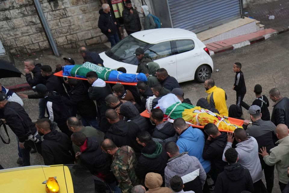 Mourners carry the bodies of four Palestinians killed by an Israeli airstrike in the West Bank city of Tulkarem (Nasser Nasser/AP)