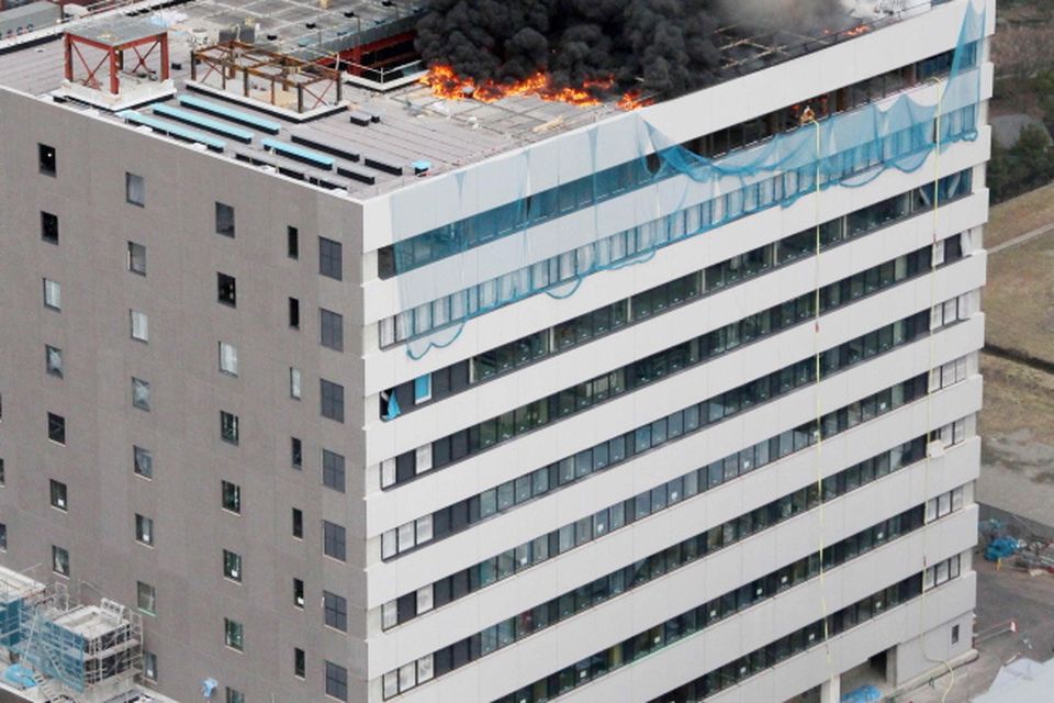 Black smoke raises from a building during a fire in Tokyo after one of the largest earthquakes on record slammed Japan's eastern coasts Friday, March 11, 2011