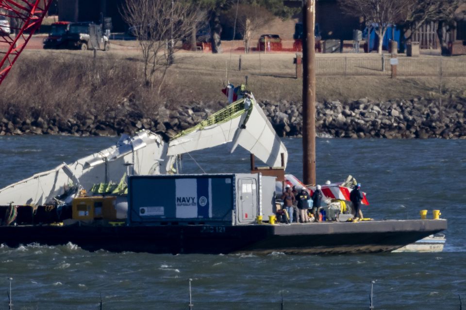 A piece of wreckage is lifted from the water on to a salvage vessel (Ben Curtis/AP)