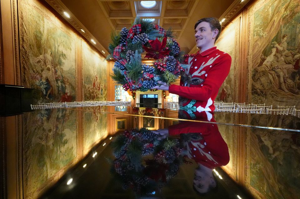 A steward prepares to hang a wreath in the tapestry room as finishing touches are made to Christmas decorations at Dumfries House (Andrew Milligan/PA)