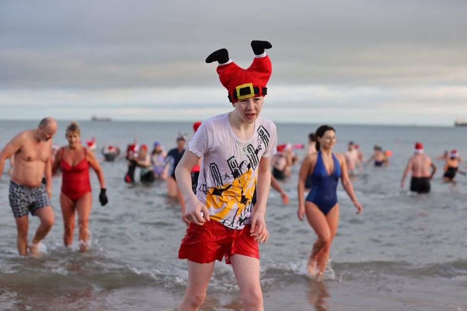 People take part in the annual Christmas Eve swim at Helen’s Bay (Liam McBurney/PA)