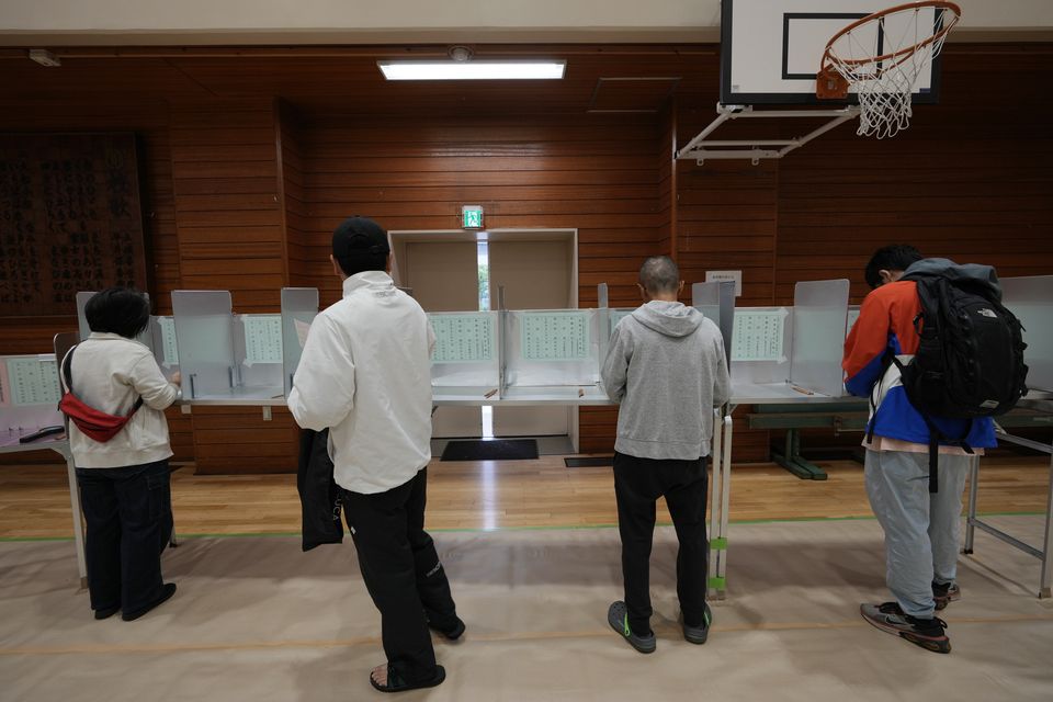 Voters cast their ballots at a polling station for Japan’s lower house election in Tokyo (Hiro Komae/AP)