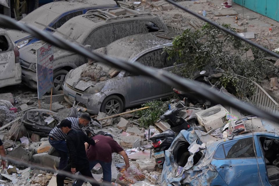 Residents check the site of an Israeli airstrike in Beirut’s southern suburbs (Hassan Ammar/AP)