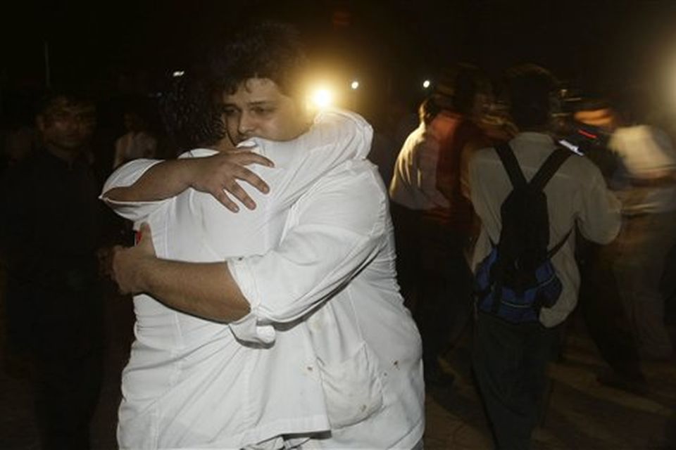 Employees of the Taj Hotel comfort each other after they were rescued from the hotel in Mumbai, India, Thursday, Nov. 27, 2008. Teams of heavily armed gunmen have stormed luxury hotels and other sites in coordinated attacks across India's financial capital, killing at least 82 people and taking Westerners hostage. (AP Photo/Gautam Singh)
