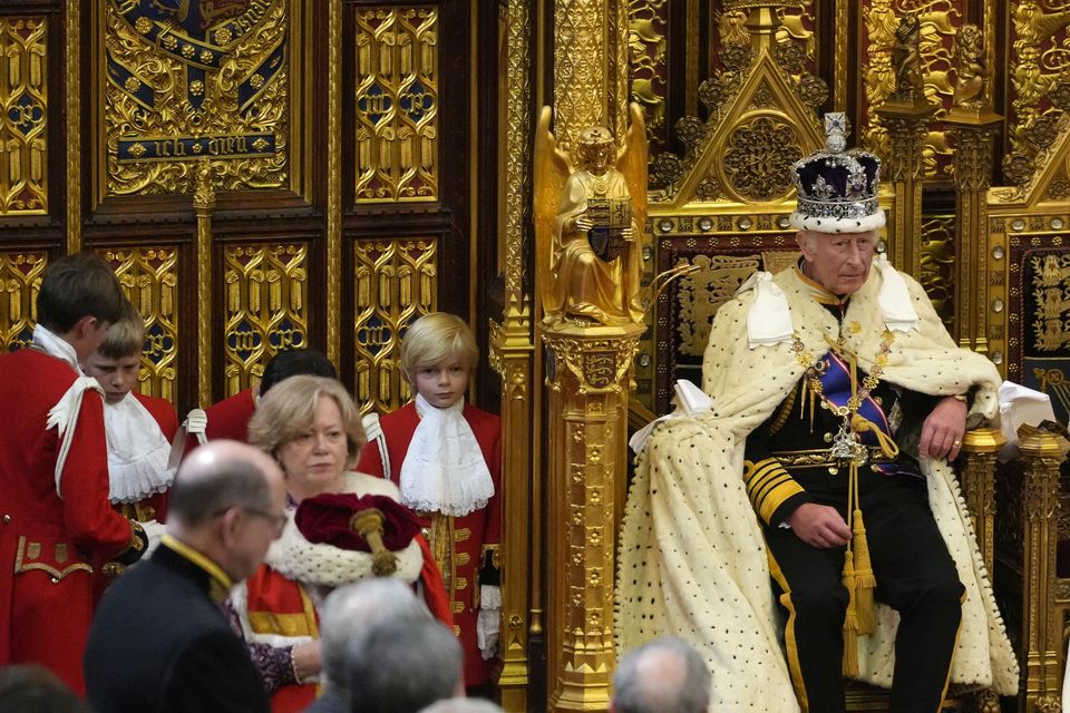 The King with his Robe of State over the arm of his chair after it was adjusted by his pages (Kirsty Wigglesworth/PA)