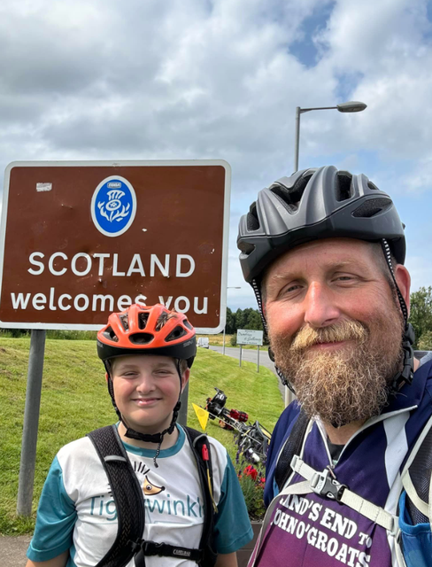 Harry Peksa and his father Nick pose at a ‘welcome to Scotland’ sign (Nick Peksa/PA)