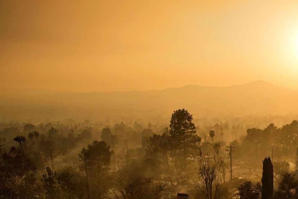 An emergency vehicle drives through a neighbourhood devastated by the Eaton fire in Altadena, California (John Locher/AP)