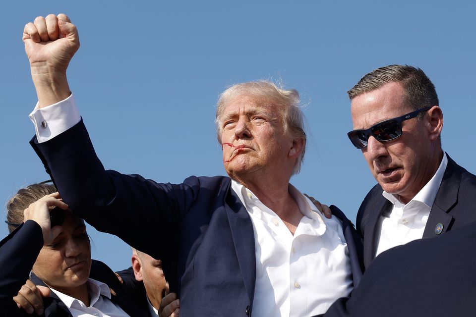 Republican presidential candidate former President Donald Trump pumps his fist as he is rushed offstage during a rally on July 13, 2024 in Butler, Pennsylvania after surviving an assassination attempt (Photo by Anna Moneymaker/Getty Images)