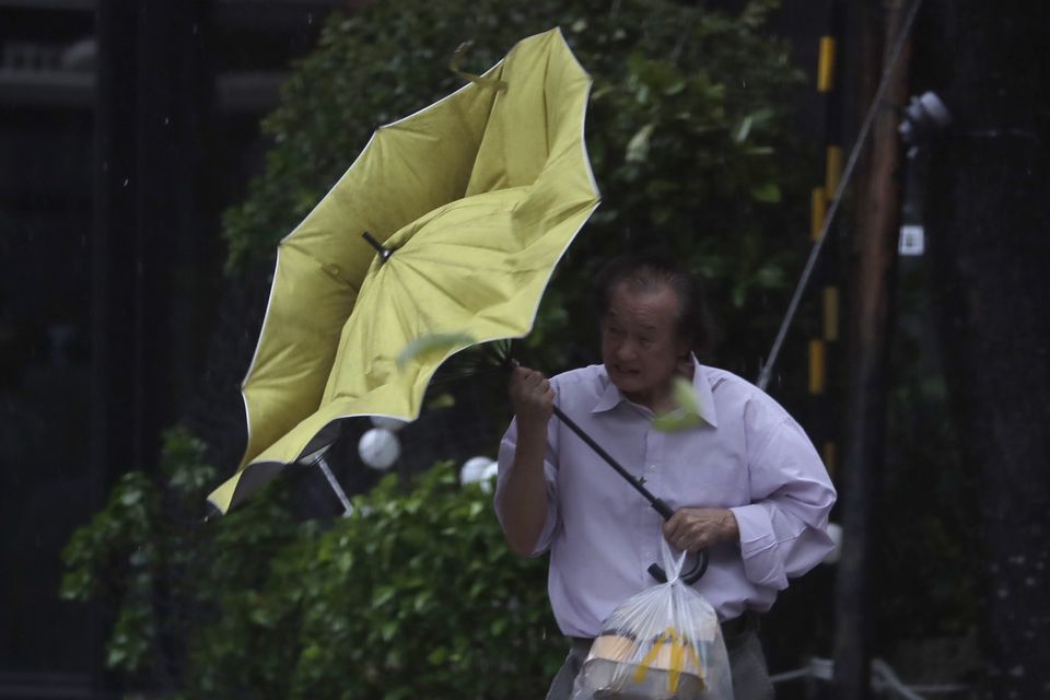 A man struggles with his umbrella against gusts of wind generated by Typhoon Kong-rey in Taipei, Taiwan (Chiang Ying-ying/AP)