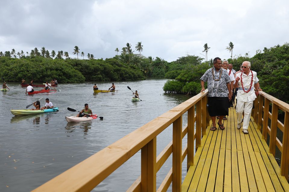 Charles and Minister Toeolesulusulu Cedric Schuster walk across a restored boardwalk during a visit to the Moata’a Village Mangrove Restoration Walk, near Apia in Samoa (Toby Mellville/PA)