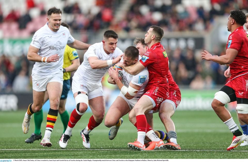 Stuart McCloskey of Ulster is tackled by Ioan Lloyd and Gareth Davies of Scarlets during the United Rugby Championship match between Ulster and Scarlets at the Kingspan Stadium in Belfast