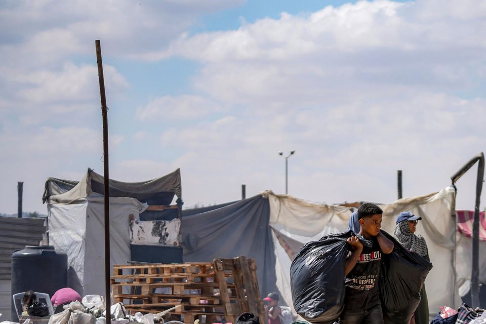 Palestinians displaced by the Israeli air and ground offensive on the Gaza Strip flee from Hamad City (Abdel Kareem Hana/AP)