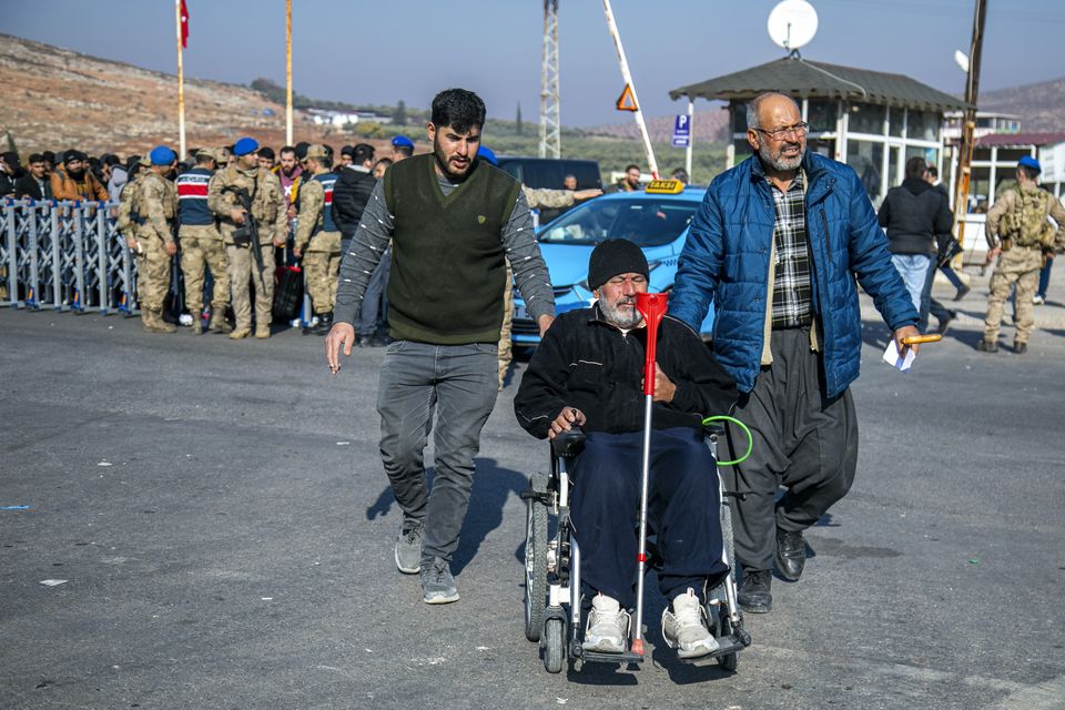 Syrians arrive to cross into Syria from Turkey at the Cilvegozu border gate, near the town of Antakya, southern Turkey (Metin Yoksu/AP)