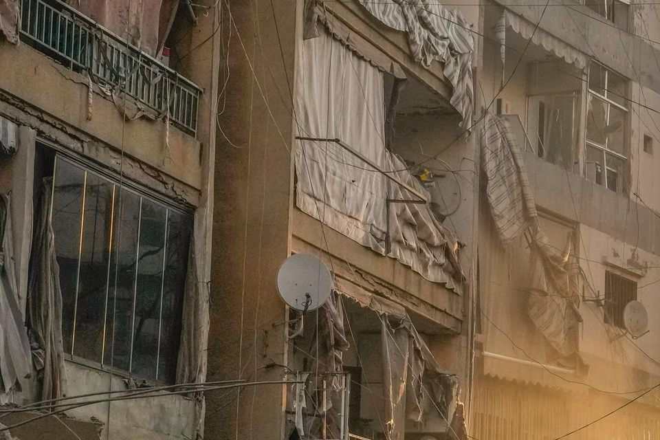 A man runs for cover as smoke rises in the background following an Israeli air strike in Dahiyeh, Beirut, Lebanon (Hassan Ammar/AP)