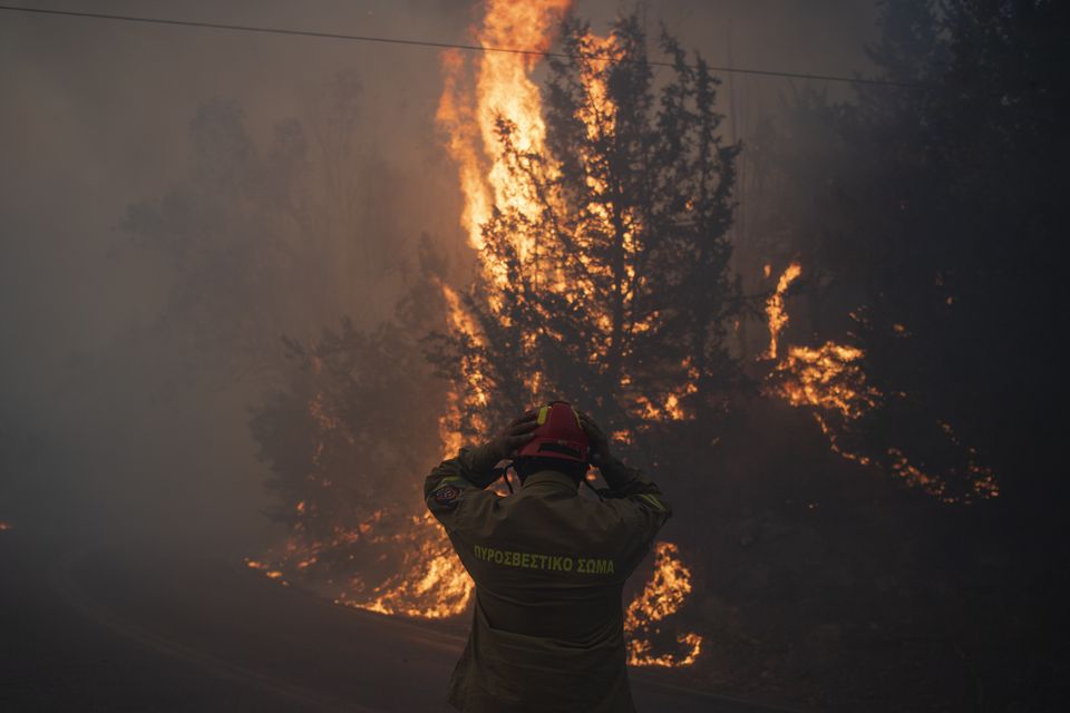 A firefighter adjusts his helmet in Varnava village, north of Athens, Greece (Michael Varaklas/AP)