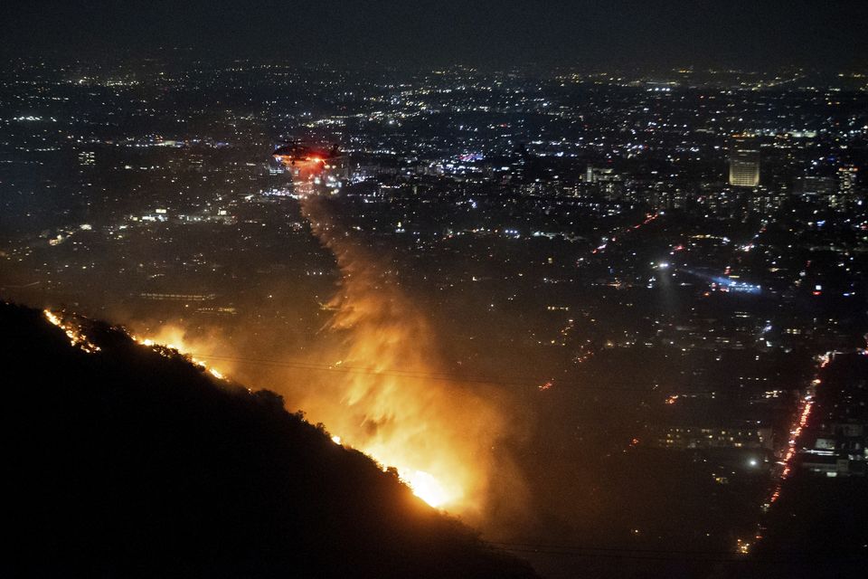 Water is dropped by helicopter on the burning Sunset Fire in the Hollywood Hills (Ethan Swope/AP)