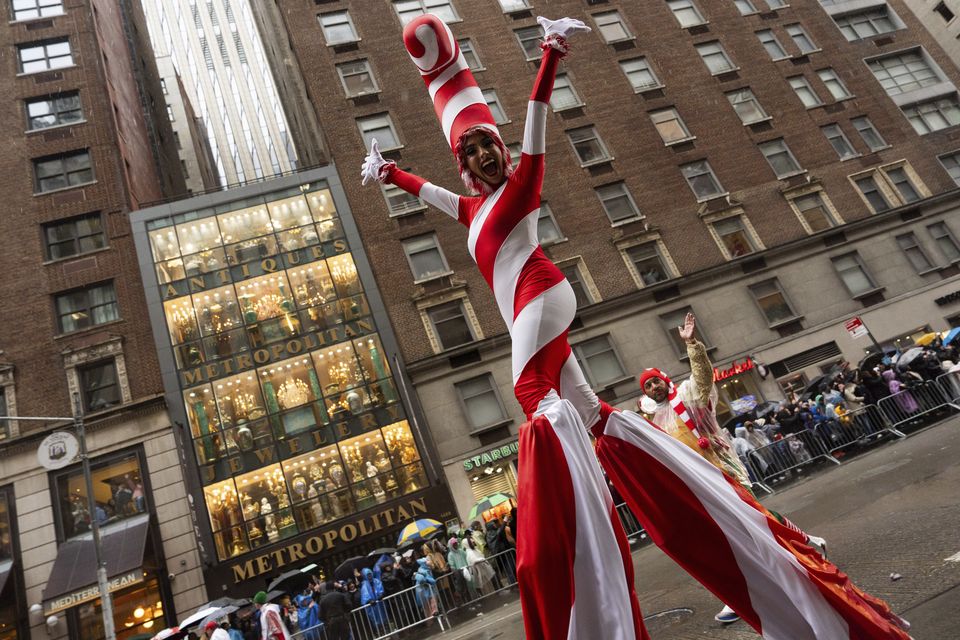 A performer dressed as a candy cane walks down Sixth Avenue (Julia Demaree Nikhinson/AP)