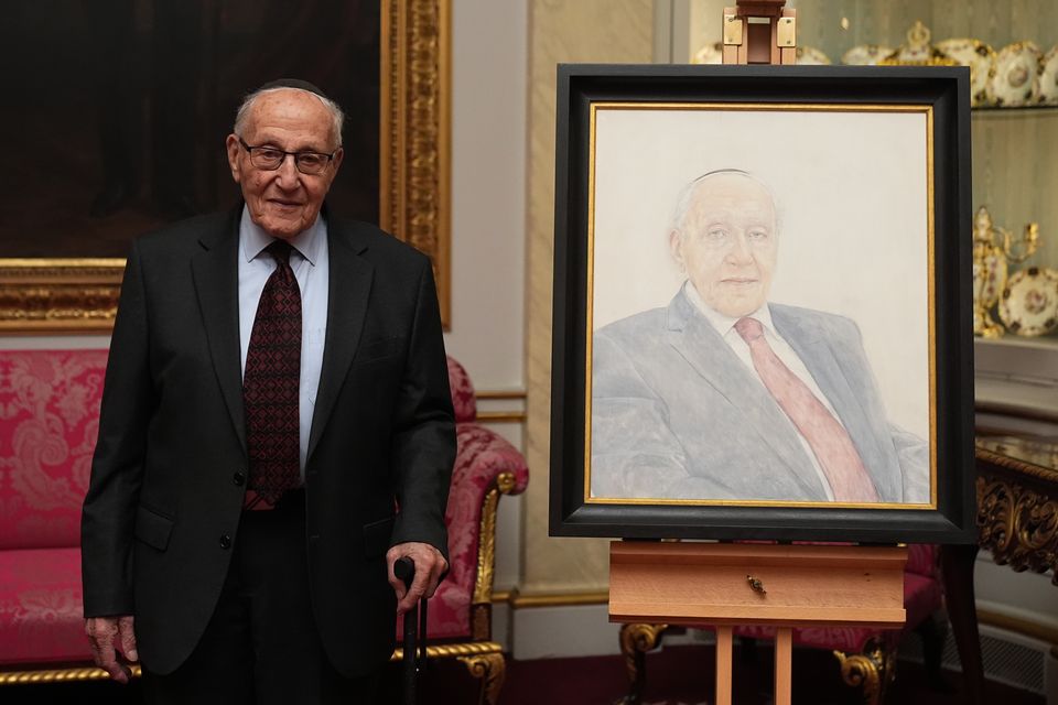 Holocaust survivor Manfred Goldberg poses beside a portrait of himself during a reception marking Holocaust Memorial Day at Buckingham Palace (Aaron Chown/PA)