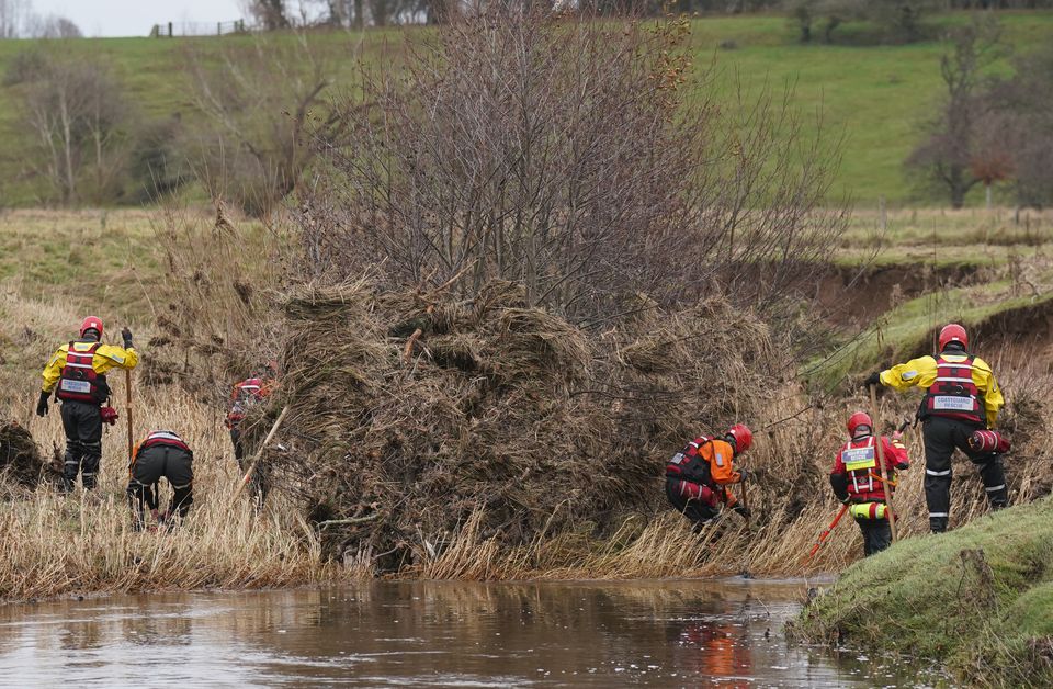 Members of a search and rescue team search through the debris in the river during the search operation at Abberwick Ford on the River Aln near Alnwick, Northumberland (Owen Humphreys/PA)