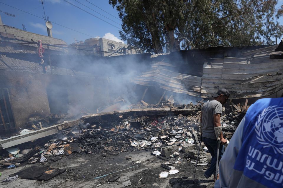 Palestinians look at the destruction after an Israeli strike on a school run by UNRWA in Nuseirat, Gaza Strip (AP Photo/Abdel Kareem Hana, File)