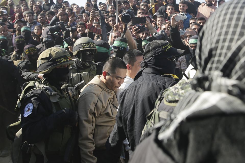 Two Thai captives are escorted by Hamas fighters (Jehad Alshrafi/AP)