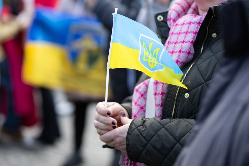 Those who attended the commemoration at Belfast City Hall held Ukraine flags. Image: Luke Jervis.