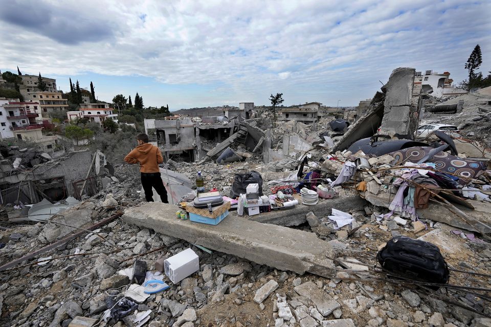 A person stands next to remains of his family home after he returned to Chehabiyeh village, southern Lebanon (Hussein Malla/PA)