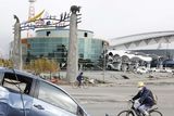 thumbnail: A man cycles past a wrecked car following the earthquake triggered tsunami at the port in Sendai, Japan (AP)
