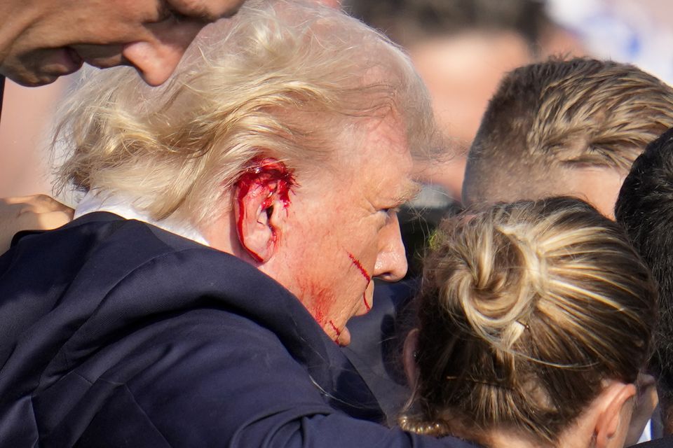 Former president Donald Trump is escorted to a motorcade following an attempted assassination at a campaign event (Gene J Puskar/AP)