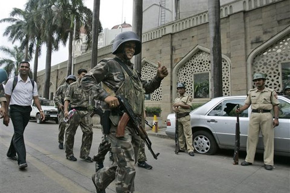 Indian commandos show the thumbs-up sign after the completion of their operation inside Taj Mahal hotel, background, in Mumbai, India, Saturday, Nov. 29, 2008. Indian commandos killed the last remaining gunmen holed up at the luxury Mumbai hotel Saturday, ending a 60-hour rampage through India's financial capital by suspected Islamic militants that killed people and rocked the nation. (AP Photo/Gurinder Osan)