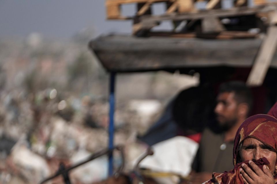 A Palestinian woman flees the Khan Younis area of the Gaza Strip (Abdel Kareem Hana/AP)