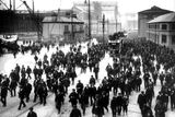 thumbnail: The shipyard men leaving Queen's Island at the end of a working day in May 1911. Some of them have boarded electric trams for parts of the city beyond walking distance. In the background the Titanic can be seen under her huge gantry. Photograph © National Museums Northern Ireland. Collection Harland & Wolff, Ulster Folk & Transport Museum